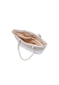 Sac à main blanc ouvert avec un intérieur beige clair, présentant des compartiments et une fermeture éclair, mettant en valeur son design et sa fonctionnalité.
