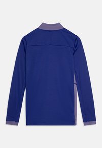 T-shirt à manches longues en bleu profond avec un col violet clair. Dispose d'un design en panneaux au dos et d'une texture de tissu lisse et légère.