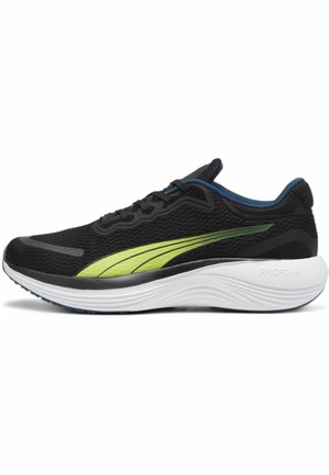 Chaussure de running noire avec une bande latérale verte, une doublure intérieure bleue, une semelle blanche amortissante étiquetée "PROFOAM" et une tige en mesh avec des lacets.