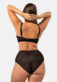 Set di lingerie nera con reggiseno trasparente a stampa leopardata e slip a vita alta coordinati. Spalline regolabili e tessuto morbido e testurizzato.