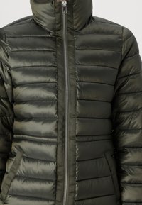 Giacca imbottita di colore verde scuro, con colletto alto, chiusura con zip e texture a righe orizzontali, dotata di tasche laterali.