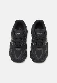 Bottes de sport noires avec une tige en mesh et en synthétique. Les caractéristiques incluent des lacets, un col rembourré, des accents de logo et une semelle texturée pour une meilleure adhérence.