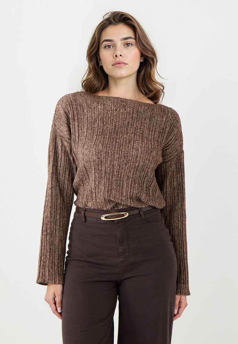 Pull en coton brun à côtes avec un col large et des manches longues, associé à un pantalon taille haute marron foncé et une ceinture brune avec une boucle en or.