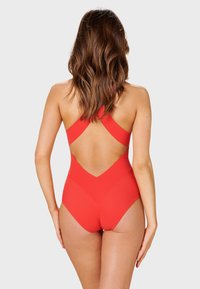 Maillot de bain une pièce rouge avec une taille haute, des bretelles croisées et un design à dos plongeant, fabriqué en tissu extensible.