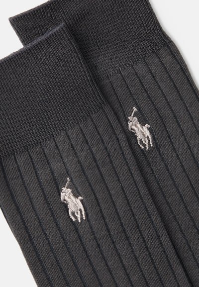 Calcetines de rayas gris oscuro con una textura suave que presentan un pequeño logotipo bordado en un color claro en el costado.