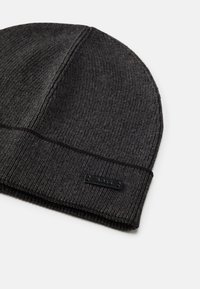 Gorro cinza de malha com acabamento texturizado. Apresenta um rótulo de marca preto na faixa dobrada e um design superior sem emendas.