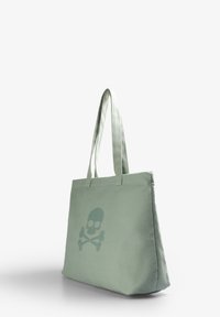 Borsa tote in tessuto verde chiaro con un design centrale di teschio e ossa incrociate. Ha due manici lunghi e una forma strutturata.