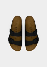 Μαύρα σανδάλια με δύο ρυθμιζόμενους ιμάντες με αγκράφες, καστανό διαμορφωμένο πέλμα και ανάγλυφη σόλα. Μέγεθος 42 αναγράφεται στο πέλμα.