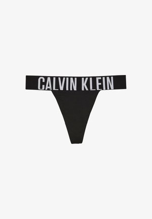 String noir Calvin Klein avec large ceinture élastique présentant le logo Calvin Klein en grandes lettres blanches.