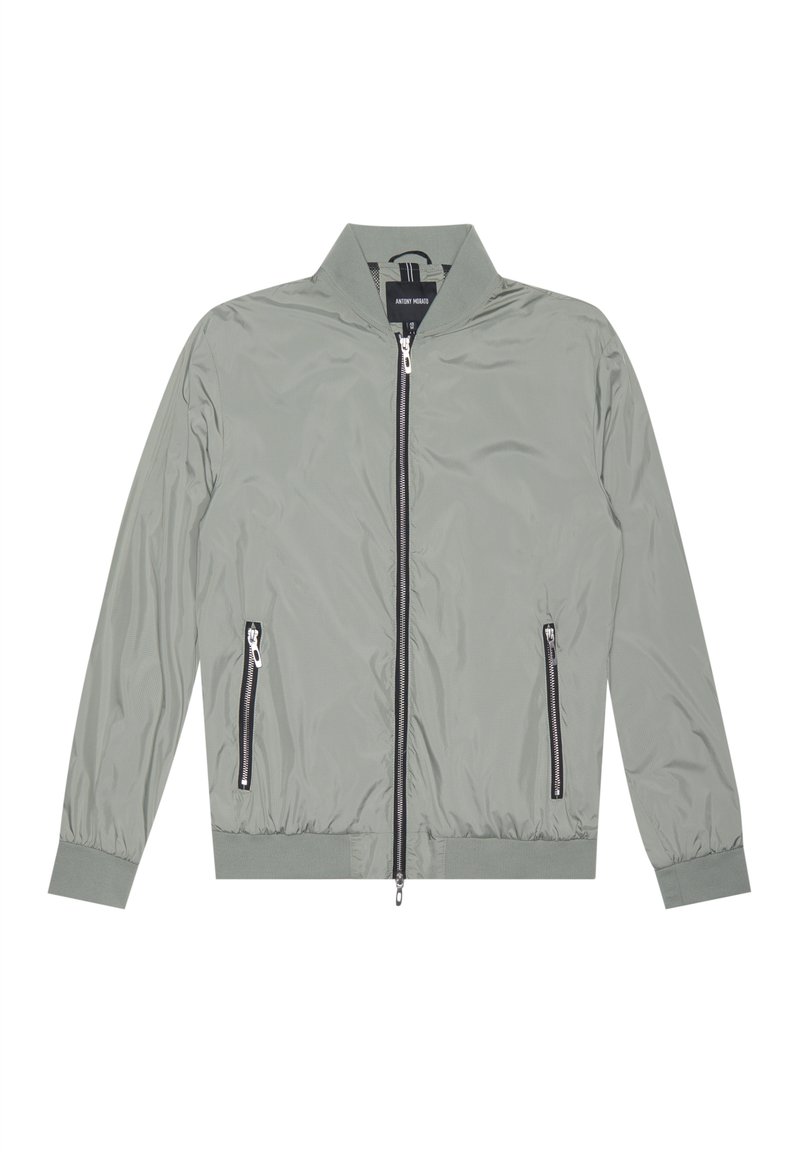 Giacca bomber grigia chiara con zip frontale, polsini e orlo a costine, due tasche laterali con zip e colletto alto. Realizzata in materiale leggero.