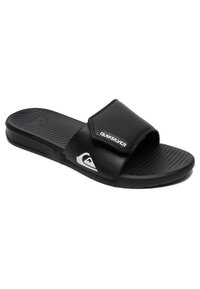 Black slide sandals made of synthetic material. Features a wide strap with "Quiksilver" logo, textured footbed, and grooved sole for grip.