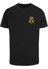 Black cotton t-shirt featuring a graphic with yellow citrus fruits and the text “IT’S OK to be different.” Positioned on the chest area.