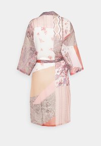 Kimono patchwork in tessuto morbido con una combinazione di motivi floreali, paisley e geometrici in tonalità di rosa pastello, bianco e beige.