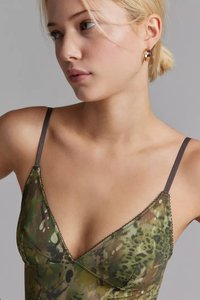 Bralette a fantasia mimetica in tonalità di verde con sottili spalline marroni e dettagli a bordo ondulato. Tessuto liscio e leggero.