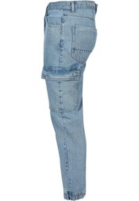 Světlé modré džínové kalhoty typu cargo s několika kapsami, zúženými nohavicemi a ohrnutými lemy. Mají klasický design s pěti kapsami a pevný materiál.