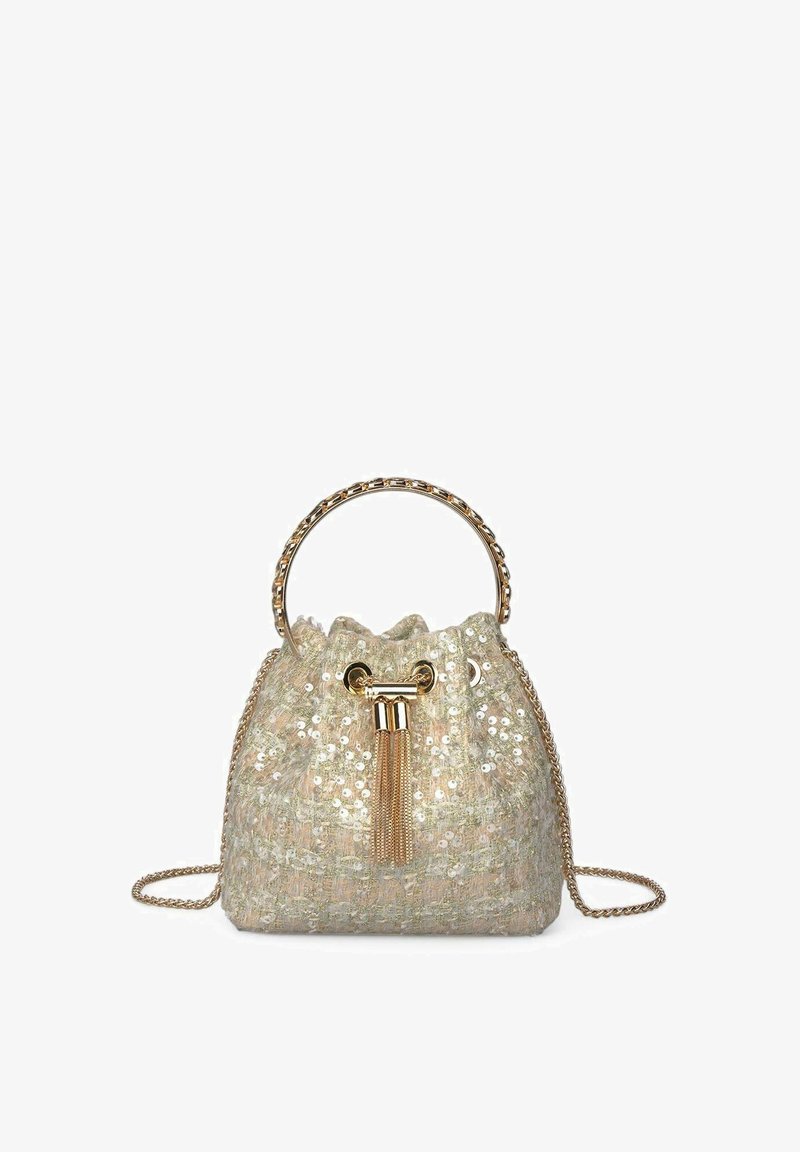 Bolso de cubo de lentejuelas beige con tejido texturizado, herrajes dorados, cierre de cuerda y correa de cadena. Presenta un detalle de borlas.