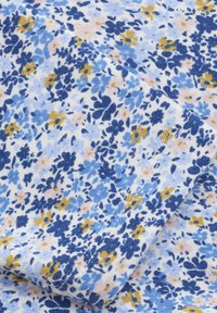 Tissu floral à base blanche présentant des fleurs bleues et jaunes. La texture est douce, avec un motif délicat et dispersé.