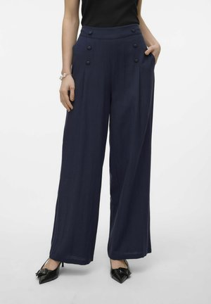 Pantalons large marine à taille haute, avec des accents de double bouton et des poches latérales. Tissu doux avec une texture lisse.