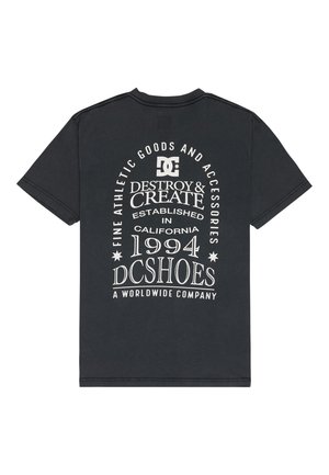 Musta puuvillainen t-paita, jonka takana on valkoista tekstiä, mukaan lukien "DC SHOES", "DESTROY & CREATE" sekä perustamisvuosi "1994". Klassinen pyöreä kaula-aukko.