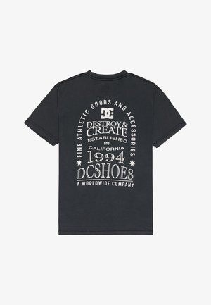 Musta puuvillainen t-paita, jonka takana on valkoista tekstiä, mukaan lukien "DC SHOES", "DESTROY & CREATE" sekä perustamisvuosi "1994". Klassinen pyöreä kaula-aukko.