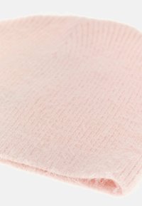Šviesiai rožinė megzta kepurė, pagaminta iš minkštos medžiagos, su raukšlėta tekstūra ir sulenkta apykakle, kad gerai priglustų.