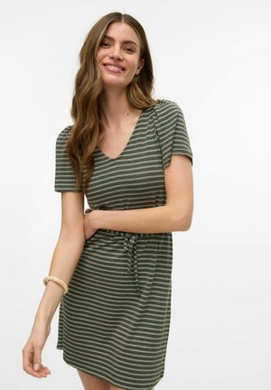 Abito a maniche corte verde con strisce verticali, scollatura a V, dettaglio della vita con nodo e morbido tessuto. Accentuato con un bracciale leggero.