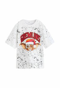 Hvid kortærmet t-shirt med sort sprøjt mønster, der har et grafik af en karakter iført en julemandshue og teksten "GREMLINS" i rød.