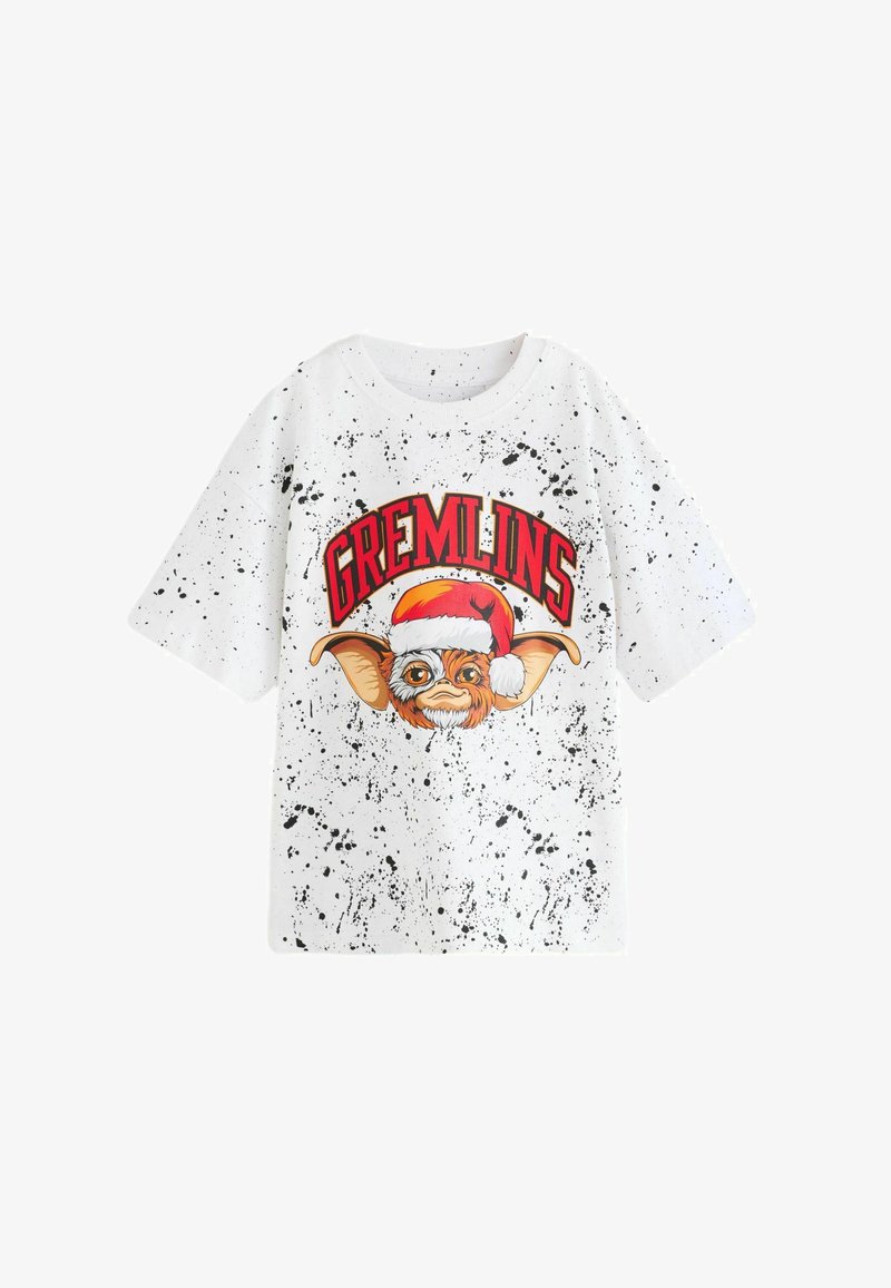 White short-sleeve t-shirt with black splatter pattern, featuring a graphic of a character wearing a Santa hat and "GREMLINS" text in red.