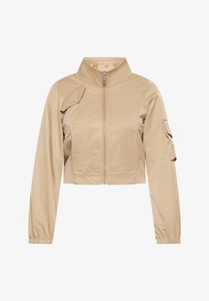 Veste beige raccourcie en tissu lisse, dotée d'un col haut, d'une fermeture zippée et d'une poche utilitaire sur la manche. Poignets élastiques.