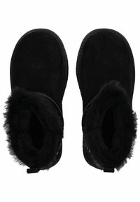 Černé semišové kotníkové boty s měkkým, huňatým interiérem a texturovanou podrážkou. Mají poutko pro snadné obouvání.