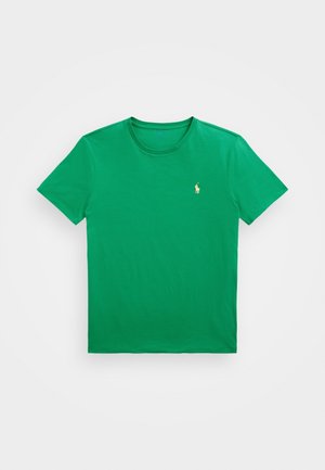 Camiseta de algodón verde con cuello redondo y mangas cortas. Cuenta con un pequeño logo bordado en dorado en el lado izquierdo del pecho. Diseño simple y sólido.