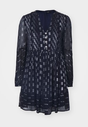 Mørkeblå kjole med lange ermer, V-utringning, sølvfargede rektangelmønstre og tre dekorative knapper foran. Gjennomsiktig stoff. Utsvingt skjørt.