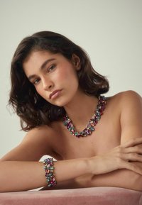 Mehrfarbige Edelsteinkette und Armband-Set, das verschiedene Formen und Texturen aufweist, mit einem metallischen Grund und filigraner Detailarbeit.