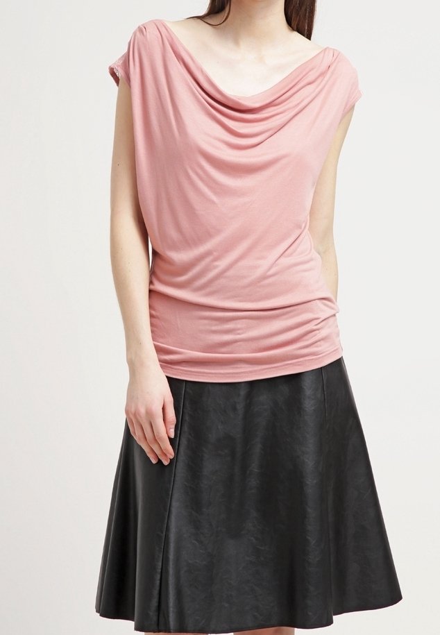 Růžový top s krátkými rukávy, zavěšený na ramenou, v kombinaci s černou koženou sukní ve tvaru A. Hladká textura látky, s nařasením kolem dekoltu.