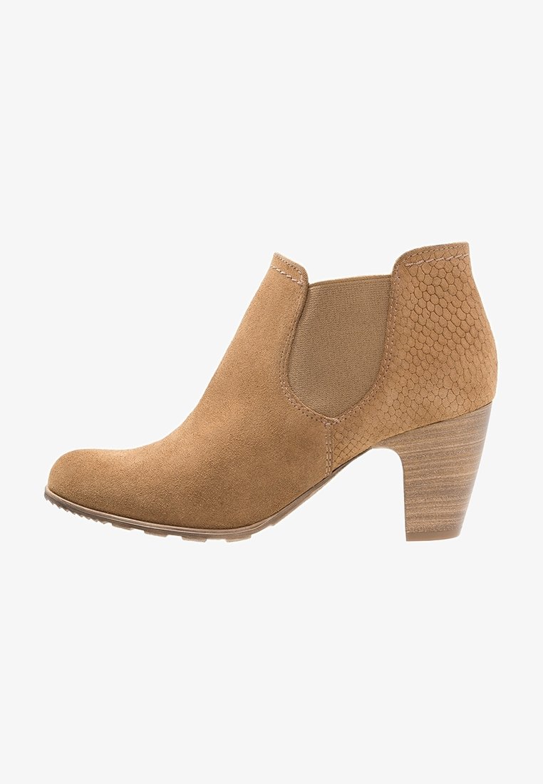 Bottine en daim camel avec panneau latéral texturé, inserts élastiques, bout arrondi et talon empilé. Détails de surpiqûres sur la tige.