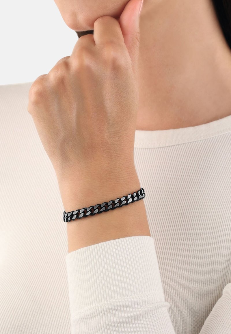 Bracciale a catena nero e argento con anelli intrecciati, caratterizzato da una superficie liscia e un design che si adatta strettamente attorno al polso.