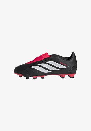 Botas de fútbol Adidas Predator negras con franjas blancas, cubierta de lengüeta roja y tacos rojos en la suela.
