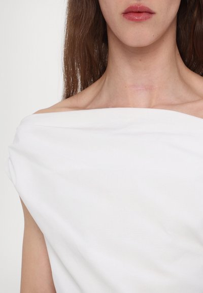 Witte off-the-shoulder top met een soepele textuur, brede halslijn en gedrapeerd fabriek. Minimalistisch ontwerp zonder zichtbare patronen of hardware.