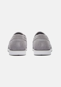 Scarpe in suede grigio con un design snodato, caratterizzate da una suola bianca e cuciture minime per un aspetto pulito. La vista posteriore mette in evidenza la texture liscia.