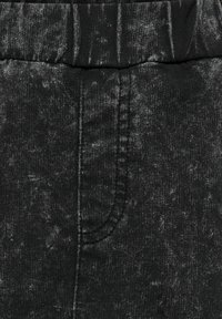 Pantaloni neri a vita elasticizzata con una trama variegata e dettagli di cucitura sottili, dalla superficie liscia e una silhouette classica.