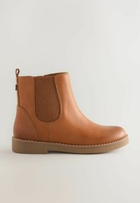 Botte Chelsea en cuir tan avec panneau latéral élastique et languette, semelle en caoutchouc plate et bout rond, présentée de profil sur un fond uni.