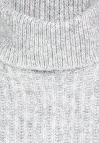 Hellgrauer gestrickter Rollkragenpullover mit gerippter Textur, ausgestattet mit einem breiten, umgeschlagenen Kragen und weichem, dickem Garn.