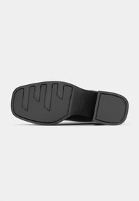 Black shoe sole with textured pattern, featuring wide grooves and a flat heel. Smooth rubber material, designed for traction and durability.