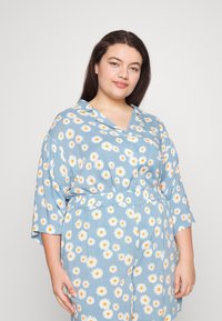 Vestido azul com padrão e anos de flores amarelas e brancas, corte solto, mangas curtas e cintura elástica. Textura do tecido suave.