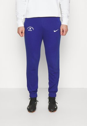 Pantaloni della tuta blu realizzati in tessuto morbido, con una fascia elastica in vita, polsini a costine e il logo Nike bianco sul lato.
