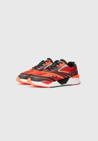 Sport sneakers with a mesh upper, featuring a mix of red and black colors, bold lines, and a cushioned sole with bright orange accents.