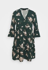 Mörkgrön blommig klänning med V-ringning, utställda ärmar och lagerdesign, med rosa och vita blommor på ett mjukt tyg.