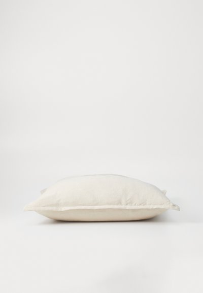 Rectangular pillow in light beige fabric. Soft texture with subtle stitching details along the edges. Flat profile, minimalistic design.