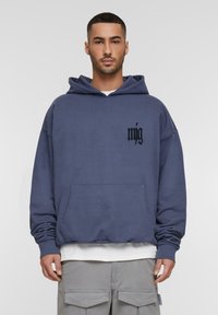 Kapuzensweatshirt aus dunkelblauem Baumwollstoff, mit einer frontalen Tasche und schwarzem gesticktem Logo auf der linken Brust. Lockerer Schnitt und gerippte Bündchen.