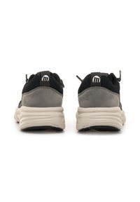 Zapatillas atléticas de malla y gamuza en negro y gris, con una suela blanca gruesa y lengüetas en la parte posterior, que presentan un logo en el talón.